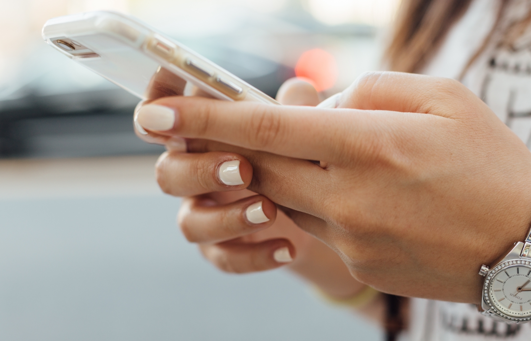 woman holding iPhone during daytime